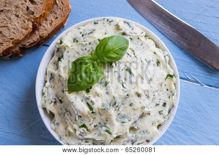 Herb Butter In A Bowl On Blue Wood