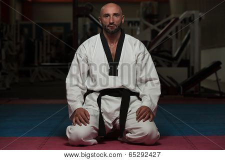 Man In A Kimono With A Black Belt Meditates