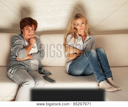 Mother with adult daughter watching television. Women looking film melodrama