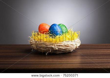 Easter Nest With Colored Eggs On Table, Gray Background