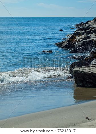 Gentle Beach Waves With A Rock Jetty