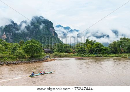 VANG VIENG LAO P.D.R. - October 24 : Unidentified tourists are rowing kayak boats in Song River on O