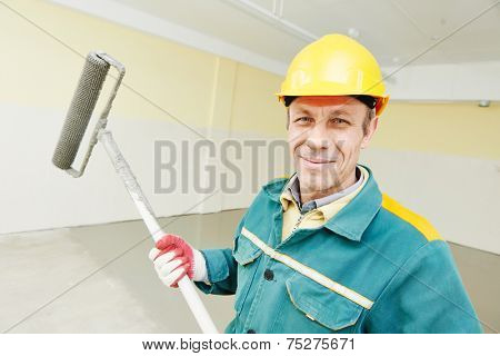 male plasterer portrait during floor covering works with self-levelling cement mortar