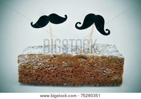 two different moustaches stuck in a piece of cake