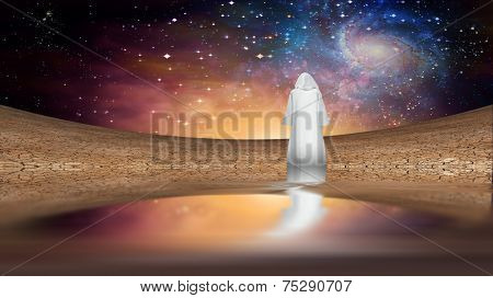 Desert and galactic sky with wandering cloaked figure Elements of this image furnished by NASA