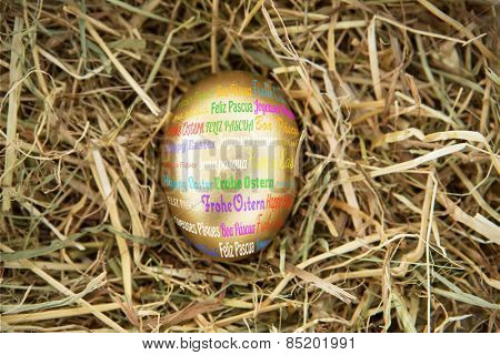 Happy easter in different languages against golden egg in the straw