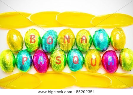 bona pascua against colourful foil wrapped easter eggs with tulip petals