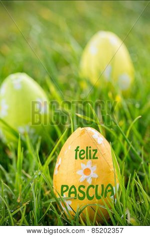feliz pasqua against easter eggs in the grass