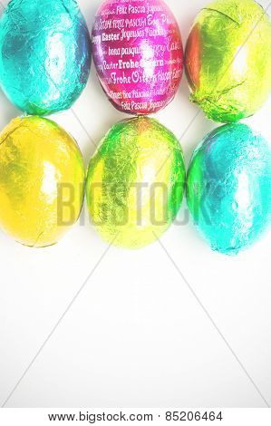 Happy easter in different languages against six easter eggs with copy space
