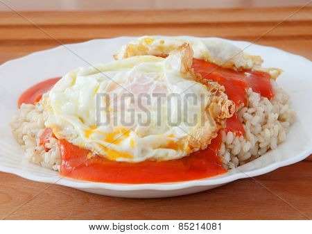Fried egg with rice overcooked and tomato sauce