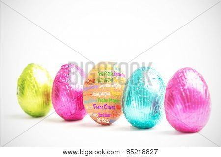 Happy easter in different languages against four easter eggs in a row with one real egg