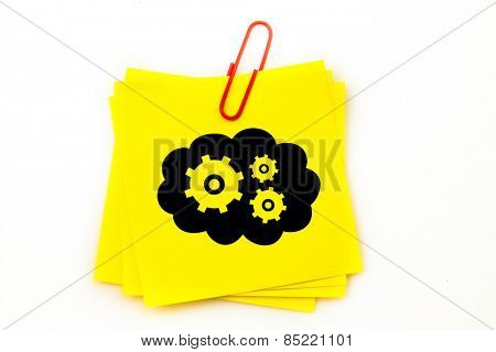 Cogs and wheels in cloud against sticky note with red paperclip