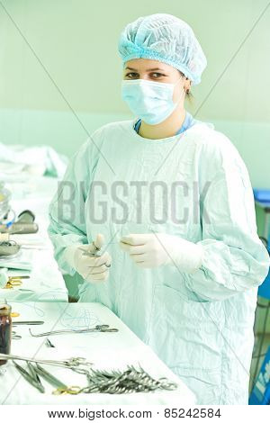 surgeon assistant nurse in uniform during heart transplantation operation on a patient at cardiac surgery clinic