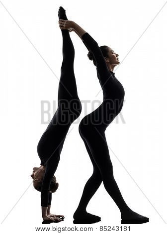 two women contortionist practicing gymnastic yoga in silhouette on white background