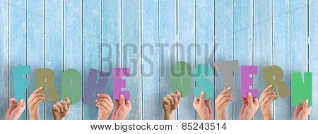 Hands holding up frohe ostern against wooden planks