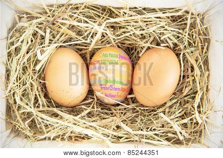 Happy easter in different languages against three eggs in a basket