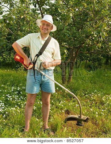 Člověk pracuje s bezdrátové vyžínače travních porostů