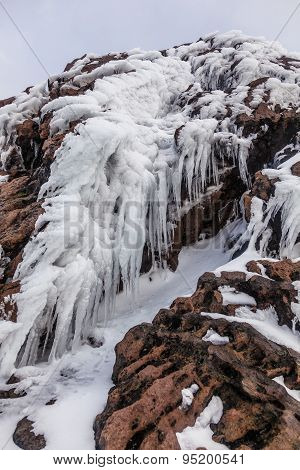 Ice Stalactites On Volcanic Rocks