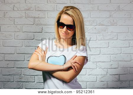 Beautiful blonde girl in branded sunglasses smiling