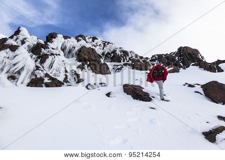 Climber Walking Through Snow, Ice And Rocks.