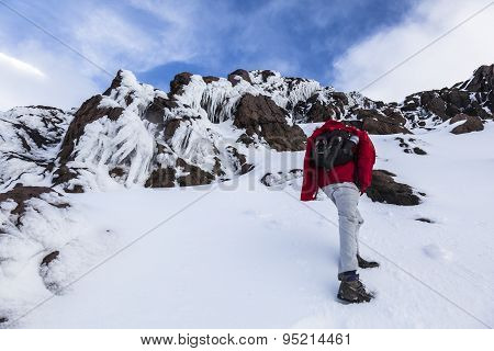Climber Walking Through Snow, Ice And Rocks.
