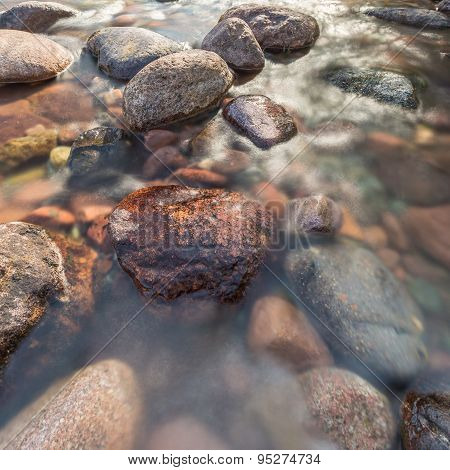 Rocks In A Fast Flowing Crystal Clear Stream