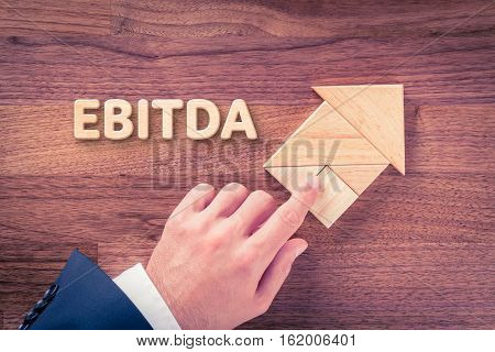 Increase EBITDA concept. Businessman plan EBITDA growth represented by arrow.