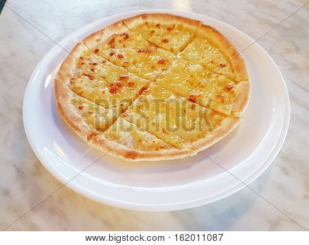 Simple freshly baked sliced cheese pizza pie served on plate