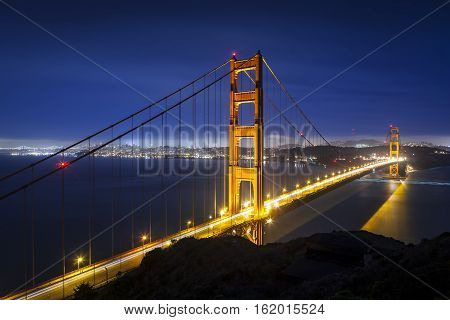 Golden Gate Bridge in San Francisco California at night with traffic light trails.