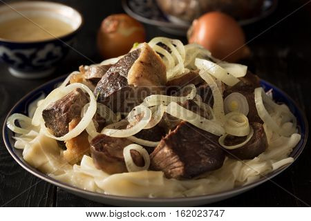 National Kazakh dish - Beshparmak prepared with boiled meat, pasta and onuin