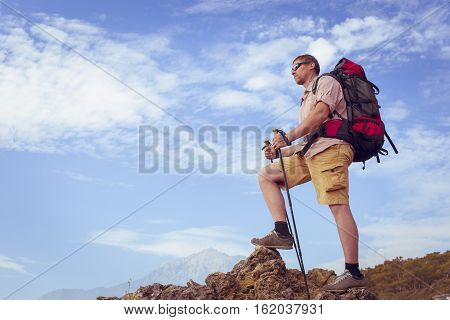 Summer hiking in the mountains with a backpack .