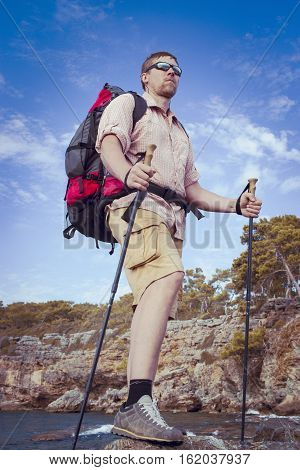 Summer hiking in the mountains with a backpack .