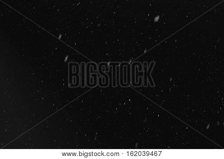 Rain or snow fall concept. Falling raindrops on black background. Just change blending mode to "Screen" and use it. Uniform droplet distribution realistic snow from the top downwards. Light spots.