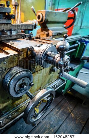 The carriage slide. Mechanical wheel carriage control. Vintage metal cutting lathe. The old mechanical cutting equipment.