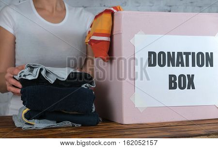 Girl prepare old son's clothes for donation