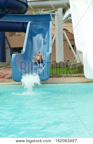 Happy teenage boy sweeming in pool with rubber ring