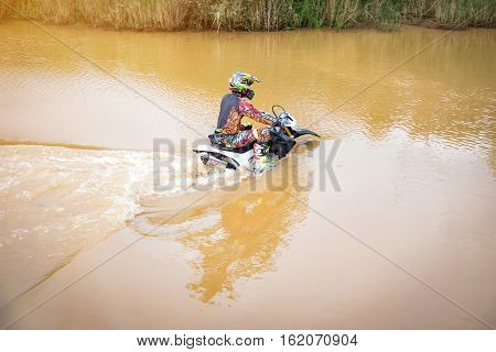 Ratchaburi,Thailand -Dec 4,2016: Motocross is trying to drive across the river to a depth of one meter in the wild.