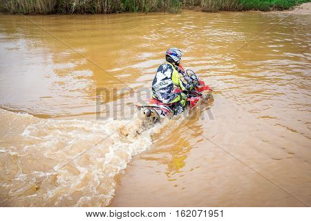 Ratchaburi,Thailand -Dec 4,2016: Motocross is trying to drive across the river to a depth of one meter in the wild.
