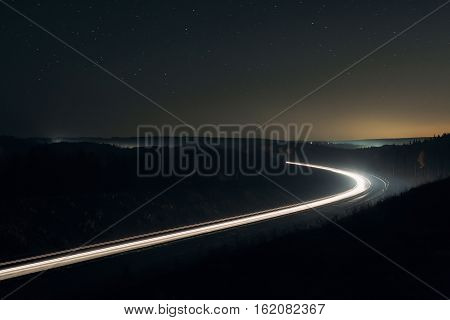 Night highway with lights under the stars