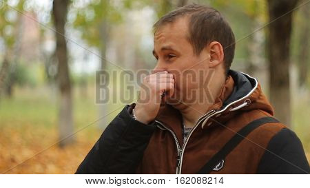 Young man in nature, smells something bad.
