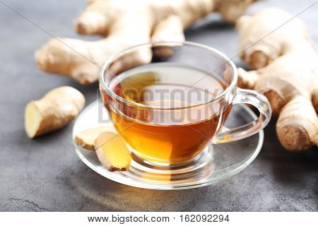 Cup Of Tea With Ginger Root On Grey Wooden Table