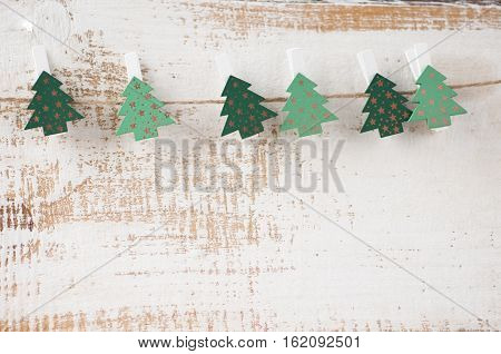 clothespins with fir trees on the ropes on top of wooden planks. Free space for text.