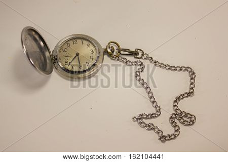 old pocket watch and chain, and a hinged lid on a white background