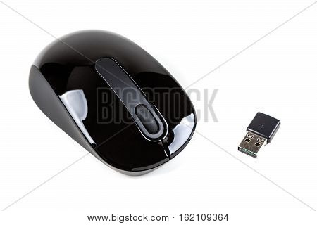 Black wireless mouse and USB dongle isolated on white background
