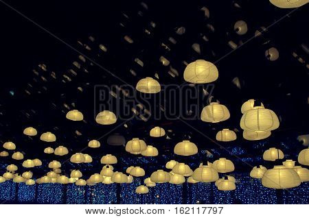Yellow retro cafe lights on the background of blue window and black roof with reflections in it. interior design loft style modern vintage decoration. Concept of relax and silence. Night in empty caffe or coffee shop.