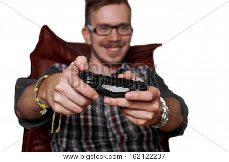 25 years old gamer play console on chair isolated on white background. Focus on joystick. Game concept. Happy man with smile.