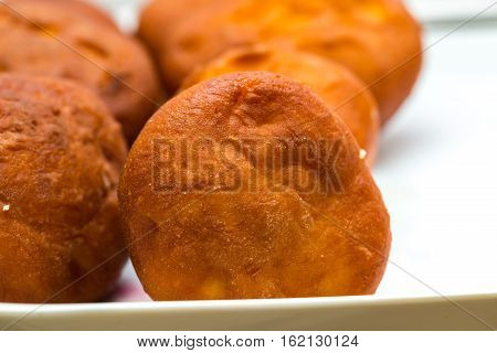 Donuts frying in deep fat. Preparation of traditional donuts