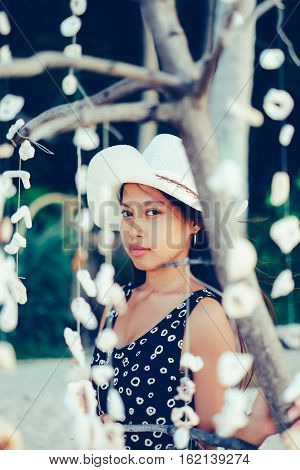 A girl behind the shells on the beach
