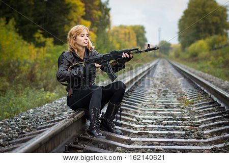 Girl with arms on the rails in autumn day