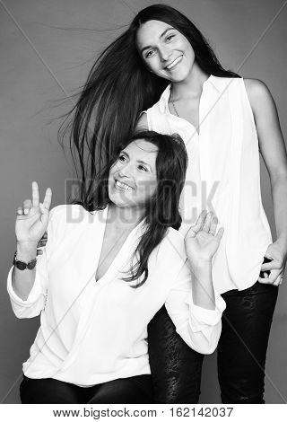 cute pretty teen daughter with mature mother hugging, fashion style brunette makeup close up tan s, mono colors, black and white lifestyle